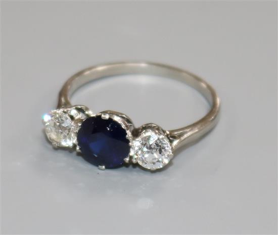 A platinum, sapphire and diamond three stone ring, size M.